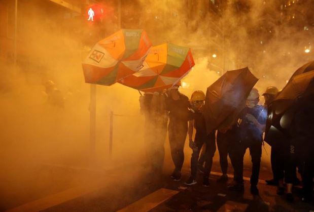 محتجون مؤيدون للديمقراطية يحتمون من الغاز المسيل للدموع بمظلات في هونج كونج يوم 28 يوليو تموز 2019. تصوير: إدجار سو - رويترز